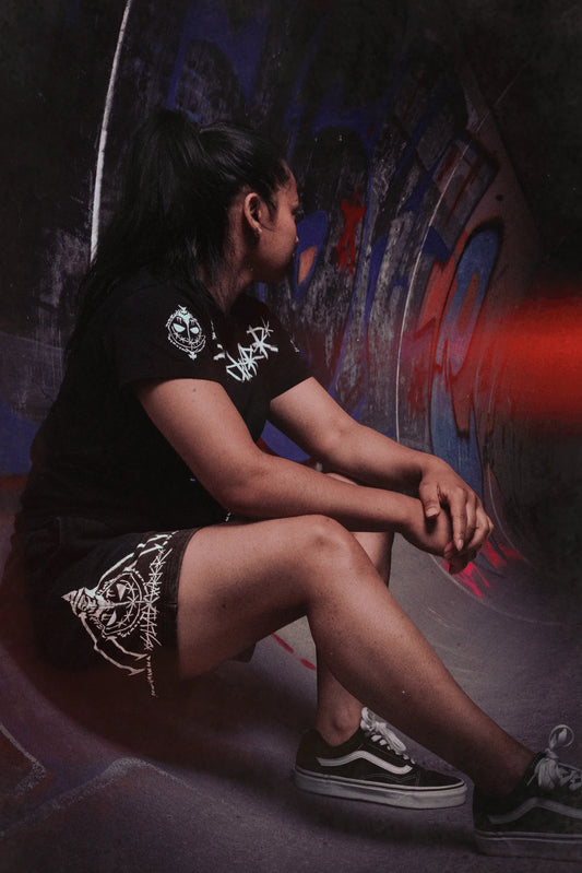 Athlete in Silent Worker powerlifting apparel sitting in a graffiti-covered skate park tunnel