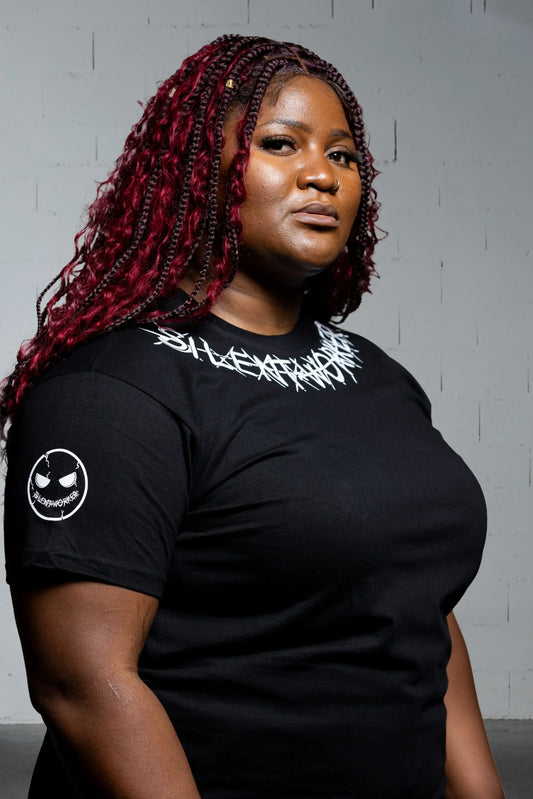 Woman wearing black Silent Worker powerlifting t-shirt with logo, studio background
