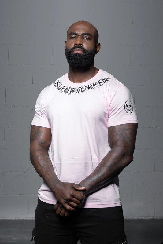 Muscular man in Silent Worker powerlifting apparel posing against a gray wall